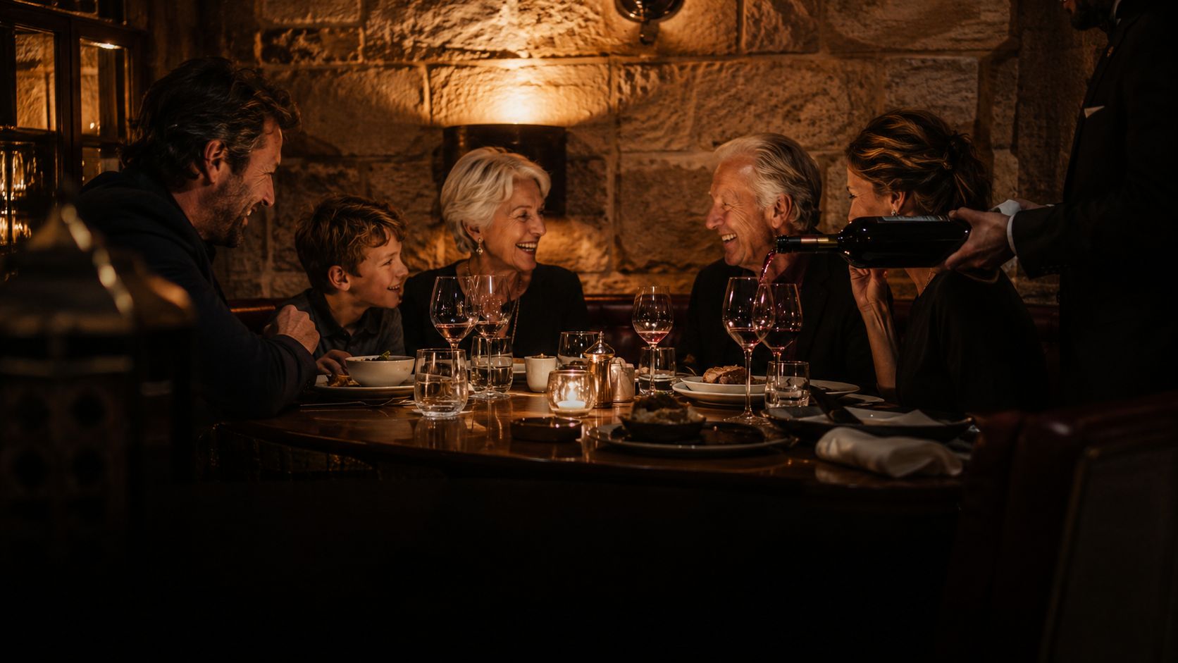 A long table mid-service, warm and intimate, the room blurred behind